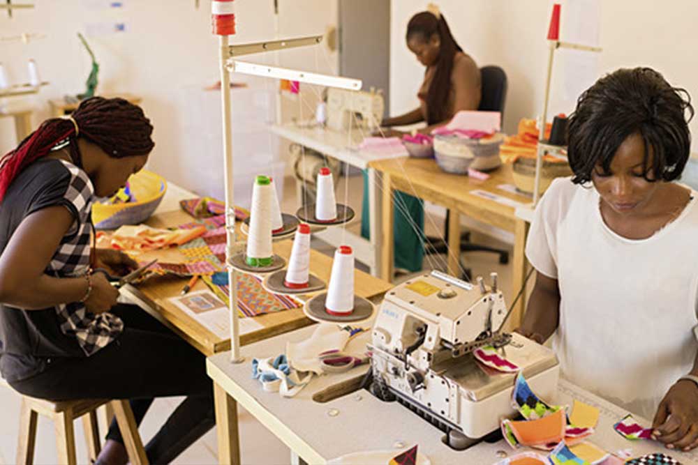 Women sewing reusable sanitary pads at ApiAfrique workshop in Senegal